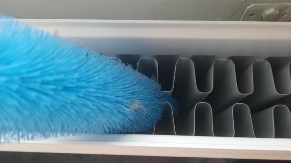 Pictured is a blue brush cleaning a radiator