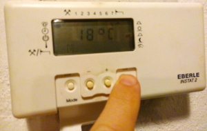 Pictured is a digital thermostate being set to 18°C